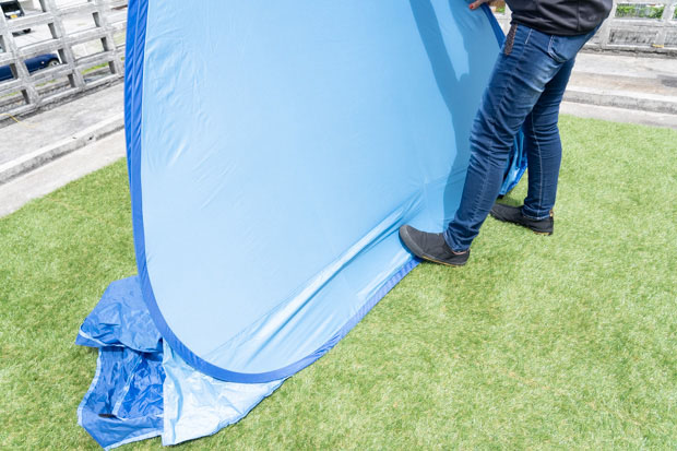 収納する際は、テントの下部を足などで固定し上部を半分に折る